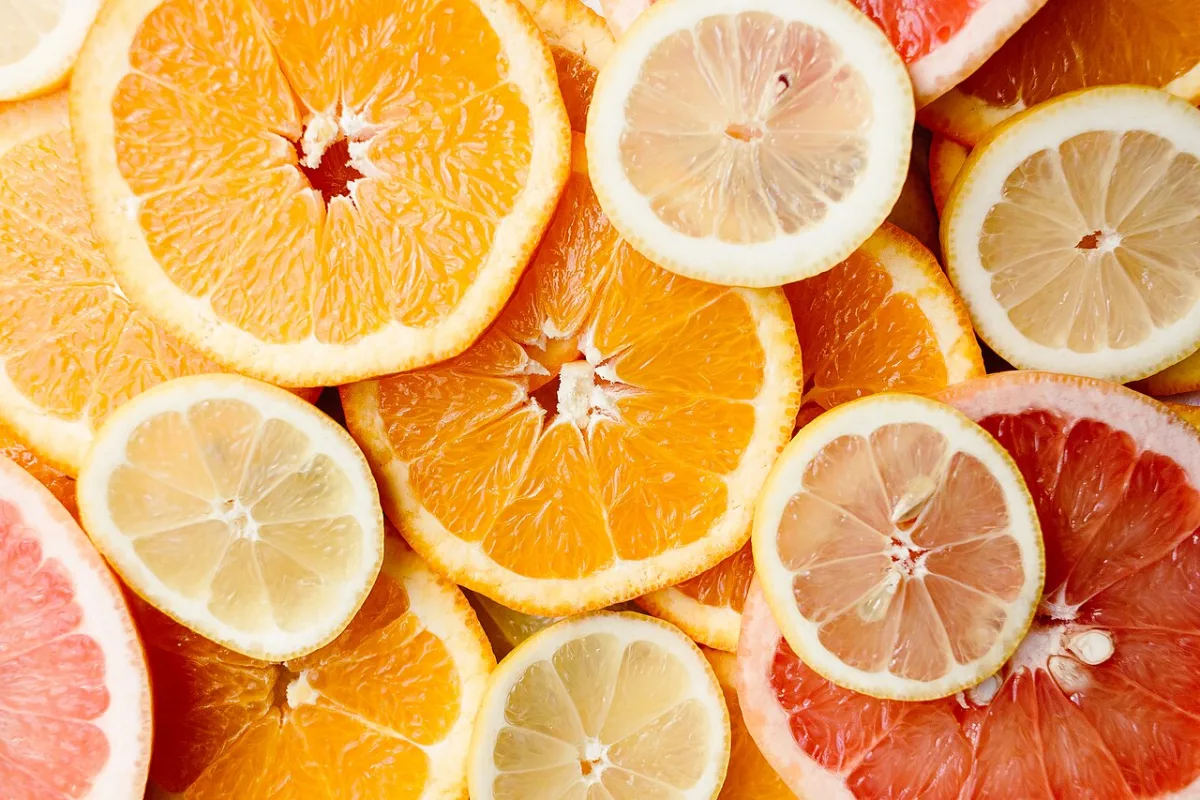 Close-up van gestapelde plakken sinaasappel, citroen, limoen en grapefruit.
